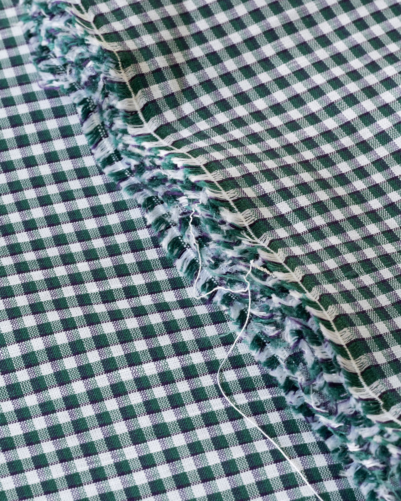 Close up image of green gingham deadstock linen cotton fabric for sewing home made clothes 
